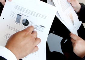 A business team reviewing charts and graphs on documents, emphasizing data analysis and teamwork.